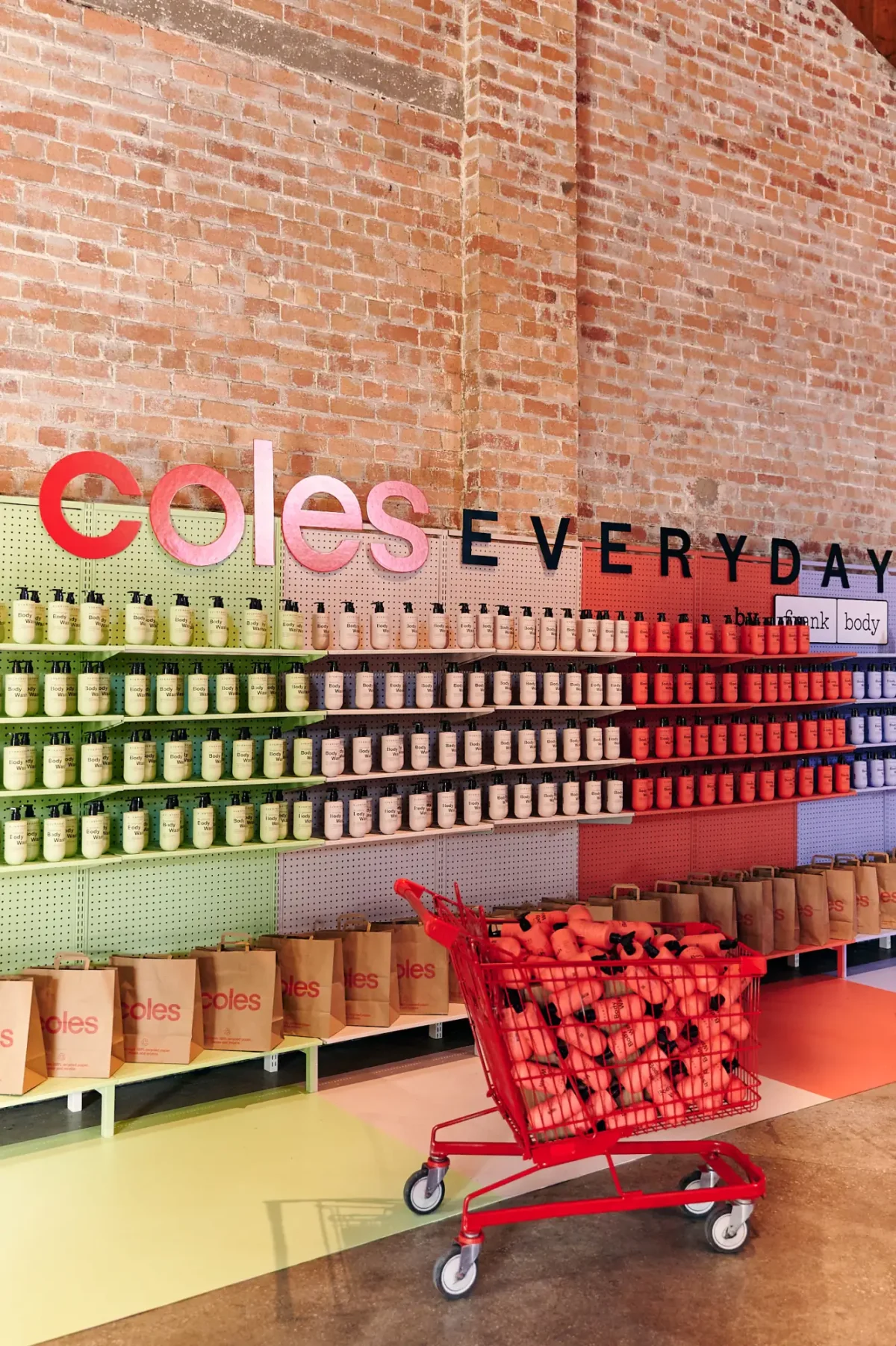 Brand activation product wall and shopping trolley installed against the brick wall at Half Acre