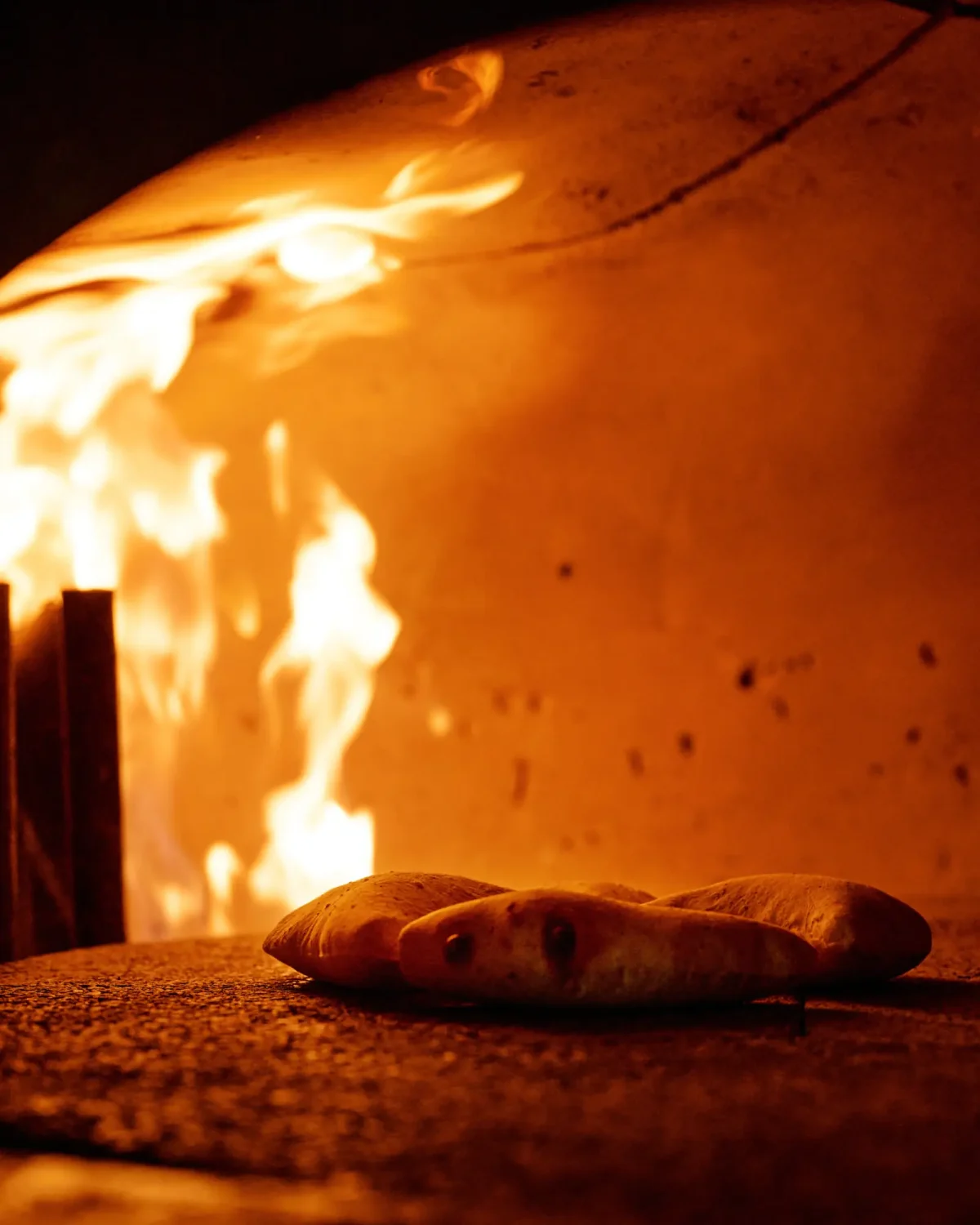 Flatbread baking beside the flames in the wood-fired oven at Half Acre