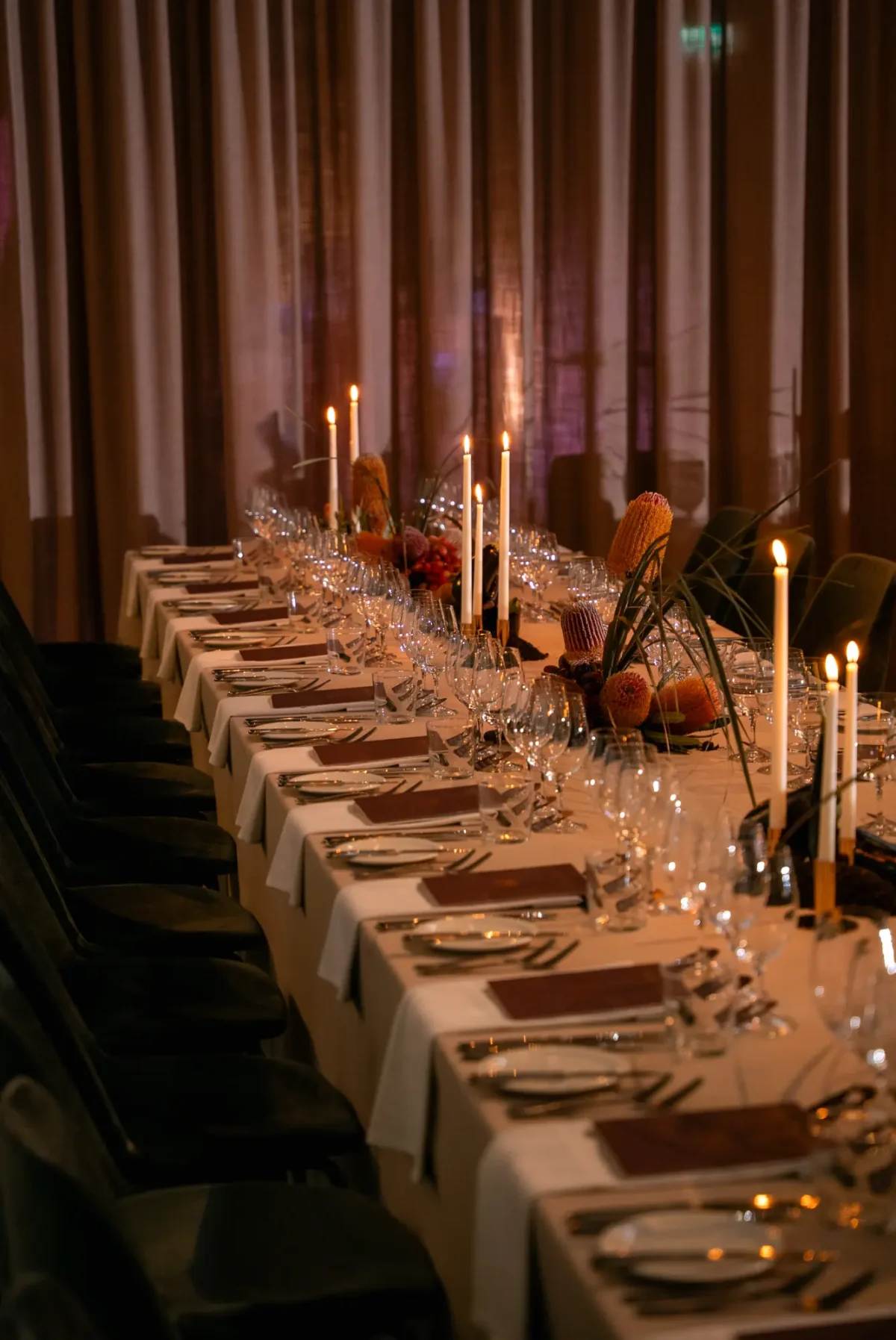Candlelit long table with native florals against velvet drapes at Half Acre