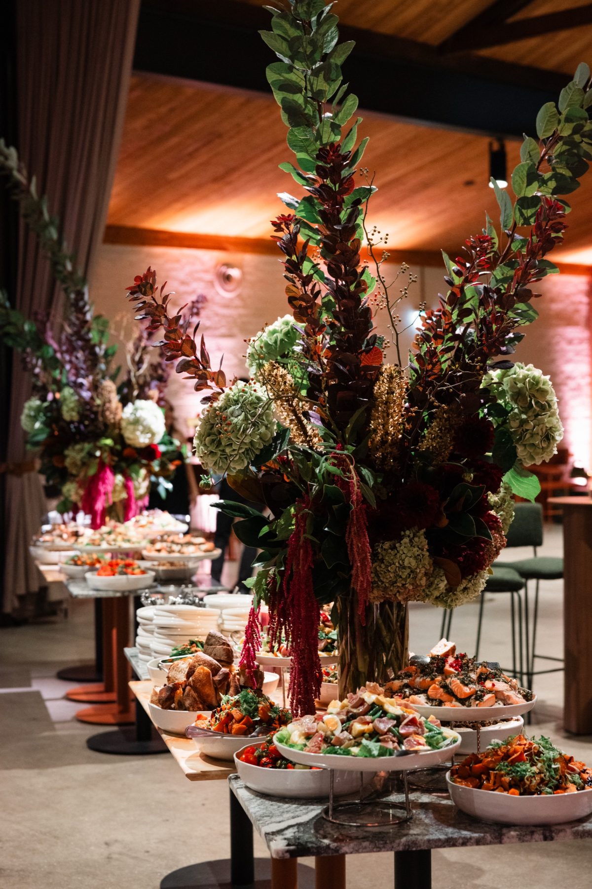 Grazing table with tall floral arrangements beneath the timber ceiling at Half Acre